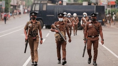 Sri Lankan police officers were seen with tear gas guns, walking along a main road as people protest against President Gotabaya Rajapaksa in a residential area after the government imposed a weekend curfew. (REUTERS)