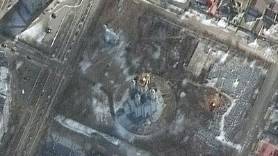 A satellite image shows first signs of excavation of a mass grave on the grounds of the Church of St. Andrew and Pyervozvannoho All Saints, in Bucha, Ukraine. (via Reuters)