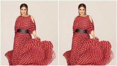 Raveena decked up in a red satin dress and looked super happy. Raveena's dress came with prints in shades of orange, white and maroon. The dress came with a belt detail near to the waist and dramatic sleeves. (Instagram/@officialraveenatandon)