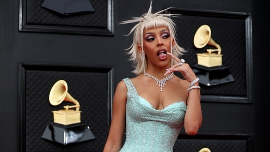 Doja Cat chose a custom Versace sequinned gown with an attached corset underneath a sheer overlay. The matching bag and a funky hairdo completed the star's look.(REUTERS)