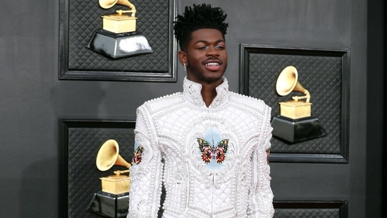 Lil Nas X made heads turn on the red carpet with his avant-garde style in a head-to-toe Balmain ensemble. He wore a white embellished jacket with matching pants and heeled boots.(REUTERS)