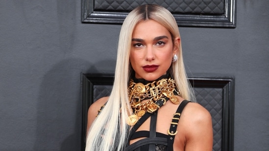 Dua Lipa debuted her brand new blonde hair on the Grammy Awards red carpet in a Versace vintage gown. The striking ensemble boasted belted strap detailing, gold jewellery and embellishments, sheer lace on the bodice, and a corset that clung to her slender frame.(Reuters)