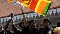 A man waves a Sri Lankan flag as people shout slogans against Sri Lanka's President Gotabaya Rajapaksa and demand that Rajapaksa family politicians step down, during a protest amid the country's economic crisis,&nbsp;