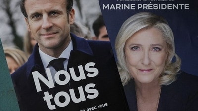 Official campaign posters of French President and centrist LREM party candidate for re-election Emmanuel Macron and Marine Le Pen, leader of French far-right National Rally (Rassemblement National) party. (Reuters)