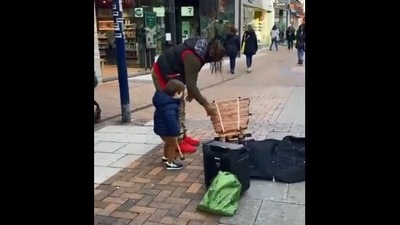 The image, taken from the Reddit video, shows the kid vibing with a street performer. (Screengrab)