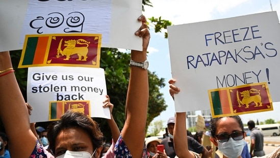 Demonstrators hold placards and shout slogans during a protest against the surge in prices and shortage of fuel and other essential commodities near the parliament building in Colombo on April 5, 2022.&nbsp;(AFP)