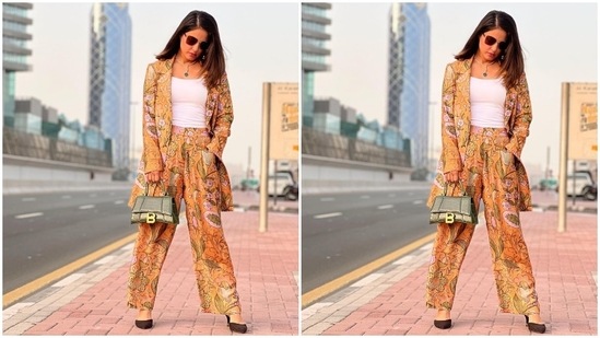 Hina teamed the blazer with matching high-waisted pants in the same floral print and mustard yellow shade. It features pleated details and a flared hem. In the end, Hina rounded off the ensemble with a white spaghetti-strapped tank top.(Instagram/@realhinakhan)