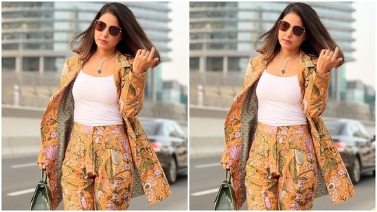 Hina picked black pointed high heels, a green patterned top handle mini bag, and tinted sunglasses to accessorise the floral patterned co-ord look.(Instagram/@realhinakhan)
