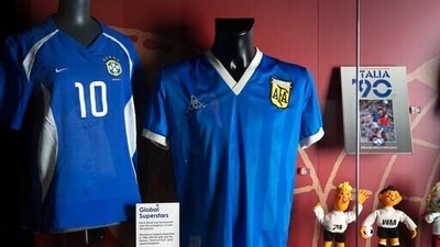 The soccer shirt (center) worn by Diego Maradona in the 1986 World Cup quarterfinal against England is displayed at the National Football Museum in Manchester (AP) The soccer shirt (center) worn by Diego Maradona in the 1986 World Cup quarterfinal against England is displayed at the National Football Museum in Manchester (AP)
