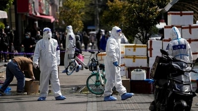 Police and security members in protective suits stand outside cordoned off food stores following the coronavirus disease (Covid-19) outbreak in Shanghai, China. (REUTERS)