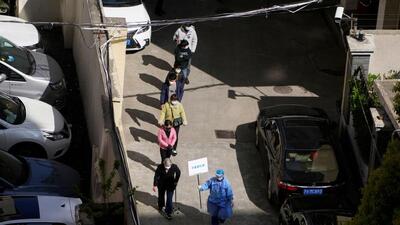 A worker in a protective suit directs residents lining up for nucleic acid testing during the second stage of a two-stage lockdown to curb the spread of Covid-19 in Shanghai, China. (REUTERS) A worker in a protective suit directs residents lining up for nucleic acid testing during the second stage of a two-stage lockdown to curb the spread of Covid-19 in Shanghai, China. (REUTERS)