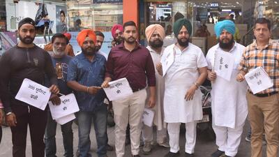 BJP leader Gurdeep Gosha with other traders holding hand fans to protest against AAP, the state government, at Clock tower in Ludhiana on April 06, 2022. (Gurpreet Singh/HT)