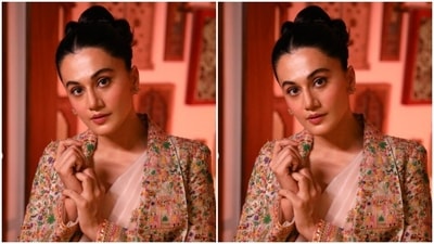 Taapsee paired an embellished corset styled blouse with an ivory white saree with minimal embroidery details. She teamed her look with an ivory white long blazer with dramatic collars and heavily decorated in colourful resham threads. (Instagram/@taapsee)