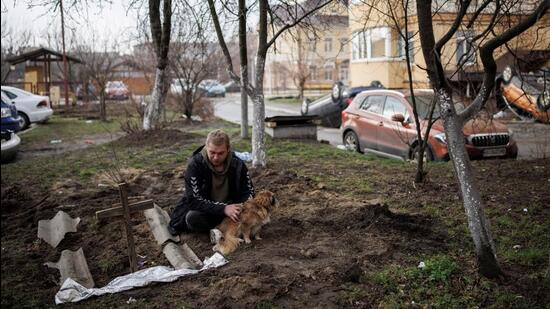 Serhii Lahovskyi, 26, mourns next to the grave of his friend Ihor Lytvynenko, who according to residents was killed by Russian soldiers, after they found him beside a building's basement, amid Russia's invasion of Ukraine, in Bucha, in Kyiv region, Ukraine. (REUTERS)