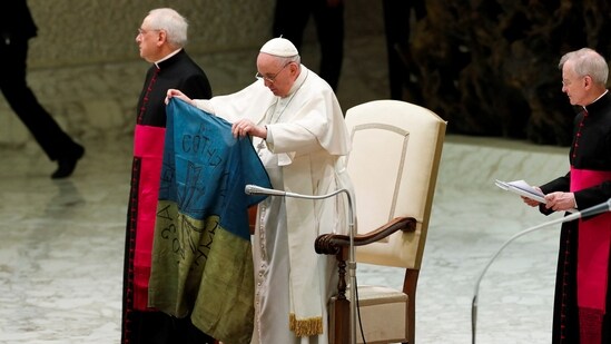 Pope Francis holds the Ukrainian flag that was sent to him from the town of Bucha.(REUTERS)