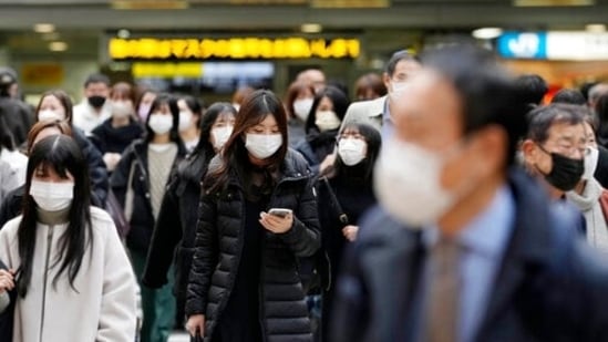 People wearing faJapan plans to ease Covid-19 related border restrictions by lifting its entry ban for foreign nationals from 106 countries including the United States, Britain and France on Friday, the government said.ce masks cross a street near JR Osaka Station in Osaka, western Japan (AP)