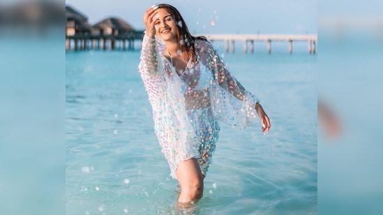 Sonakshi Sinha gets in the water wearing a white bikini top which she teamed with blue shorts and a polka-dotted beach cover-up.(Instagram/@aslisona)