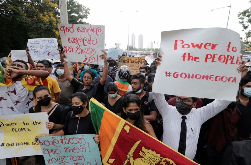 People hold placards as they demand Sri Lanka's President Gotabaya Rajapaksa to resign in Colombo on Wednesday. (REUTERS)