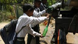School children fill their bottles from a water tank during a hot summer afternoon in New Delhi. (ANI PHOTO)