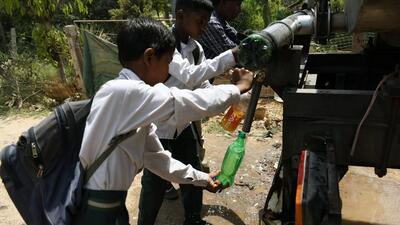 School children fill their bottles from a water tank during a hot summer afternoon in New Delhi. (ANI PHOTO) School children fill their bottles from a water tank during a hot summer afternoon in New Delhi. (ANI PHOTO)