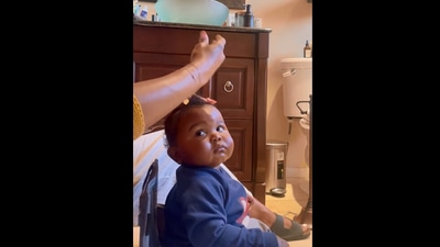 The image, taken from the video, shows the kid looking at his mom styling his hair. (Instagram/@knightsglow)