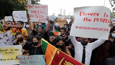 People hold placards as they demand Sri Lanka's President Gotabaya Rajapaksa to resign during a protest near to a road leading to the parliament building in Colombo. (Reuters)
