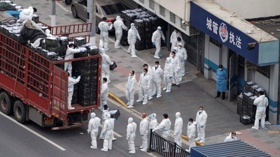 This photo shows people wearing personal protective equipment (PPE) as they transfer daily food supplies and necessities for local residents during the Covid-19 lockdown in Shanghai. (AFP) This photo shows people wearing personal protective equipment (PPE) as they transfer daily food supplies and necessities for local residents during the Covid-19 lockdown in Shanghai. (AFP)