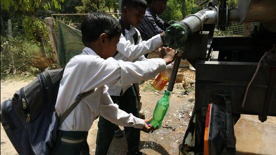 School children fill their bottles from a water tank during a hot summer afternoon in New Delhi. (ANI PHOTO)