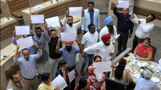 AAP and BJP councillors carrying placards to push their arguments during the special House meeting at the Municipal Corporation Office in Sector 17, Chandigarh, on Thursday. (Ravi Kumar/HT)