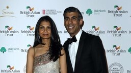 Britain's Chancellor of the Exchequer Rishi Sunak (R) poses with his wife Akshata Murty.