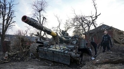 Men stand next to a destroyed tank in Chernihiv, Ukraine, Thursday, April 7, 2022. (AP) Men stand next to a destroyed tank in Chernihiv, Ukraine, Thursday, April 7, 2022. (AP)