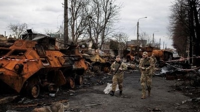 Ukrainian soldiers walk past a destroyed Russian tank amid Russia's invasion of Ukraine, in Bucha in Kyiv region in Ukraine. (REUTERS PHOTO.) Ukrainian soldiers walk past a destroyed Russian tank amid Russia's invasion of Ukraine, in Bucha in Kyiv region in Ukraine. (REUTERS PHOTO.)