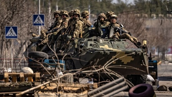 Ukrainian soldiers sit on a armoured military vehicule in the city of Severodonetsk, Donbass region.(AFP)