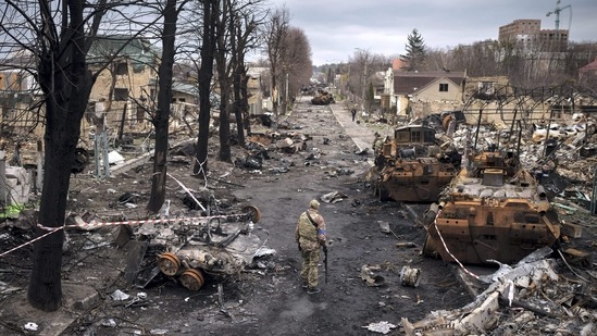 A Ukrainian serviceman walks amid destroyed Russian tanks in Bucha, on the outskirts of Kyiv, Ukraine.(AP)