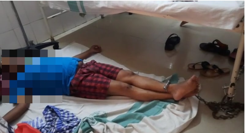 Loknath Dalei, a journalist in Balasore, was seen chained to a hospital bed by his leg. (ANI) Loknath Dalei, a journalist in Balasore, was seen chained to a hospital bed by his leg. (ANI)