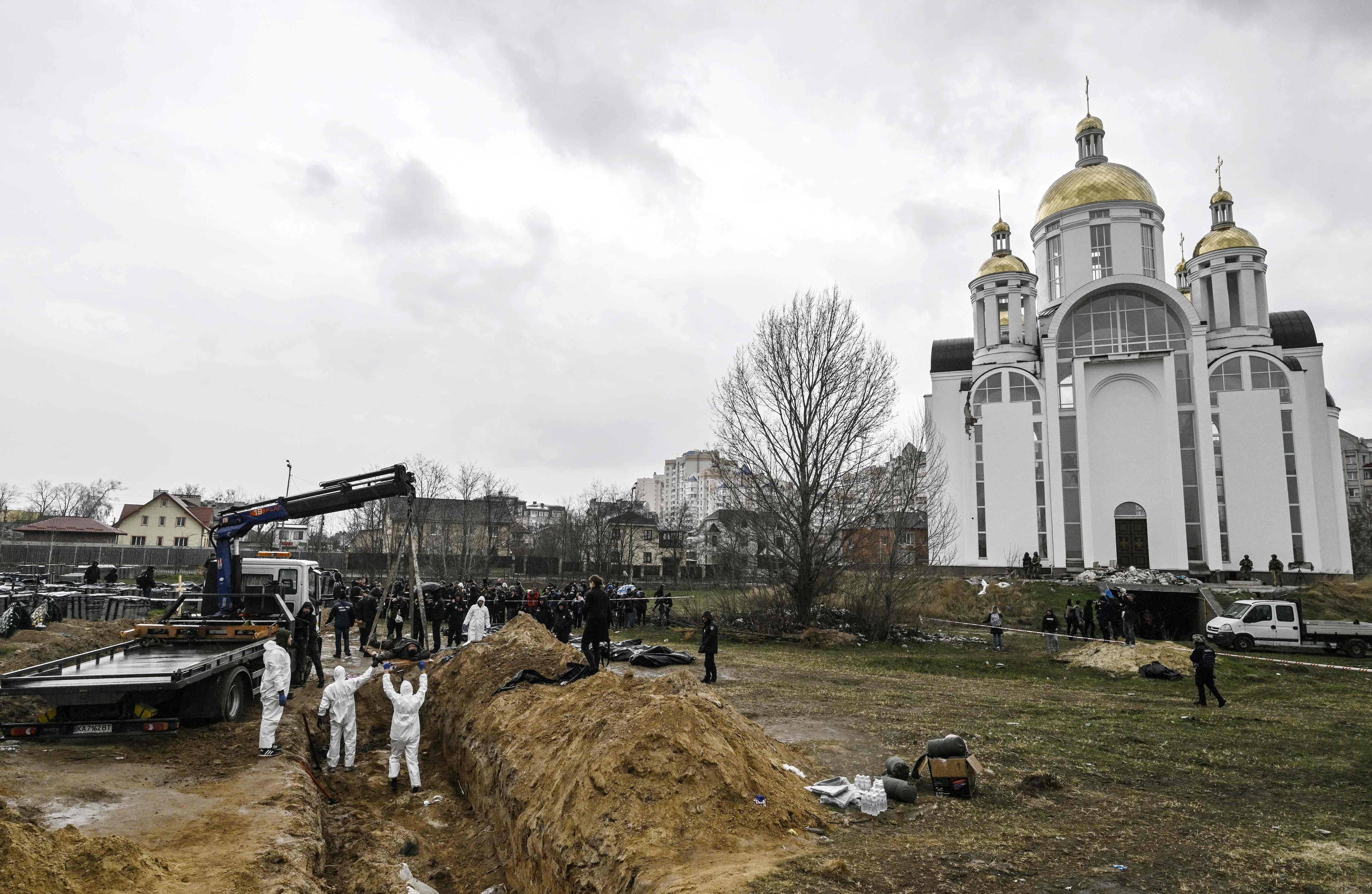 Ukrainian investigators exhume bodies from a mass grave in the gardens of the St Andrew church in the town of Bucha, northwest of Kyiv, on April 8, 2022, during Russia's military invasion launched on Ukraine. (AFP) Ukrainian investigators exhume bodies from a mass grave in the gardens of the St Andrew church in the town of Bucha, northwest of Kyiv, on April 8, 2022, during Russia's military invasion launched on Ukraine. (AFP)