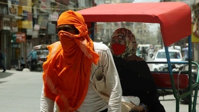 A rickshaw puller covers his face from the heatwave as temperature touches 44 degrees, in New Delhi on Wednesday. (ANI Photo)