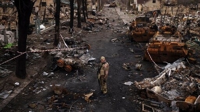 A Ukrainian serviceman stands amid destroyed Russian tanks in Bucha, on the outskirts of Kyiv, Ukraine, (AP) A Ukrainian serviceman stands amid destroyed Russian tanks in Bucha, on the outskirts of Kyiv, Ukraine, (AP)