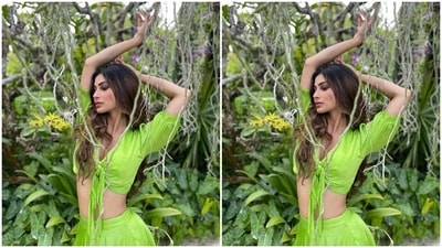 Mouni's outfit features a green blouse with front knot detail, a plunging V neckline, half sleeves with gathered cuffs, and a midriff-baring hem. The star wore the silk satin top with a long and flowy skirt. (Instagram/@imouniroy) Mouni's outfit features a green blouse with front knot detail, a plunging V neckline, half sleeves with gathered cuffs, and a midriff-baring hem. The star wore the silk satin top with a long and flowy skirt. (Instagram/@imouniroy)