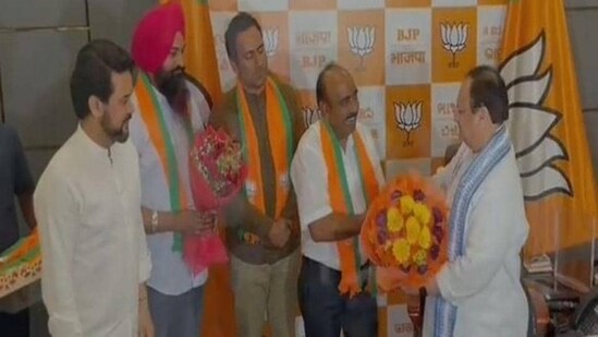 Aam Aadmi Party Himachal Pradesh unit president Anup Kesari, general secretary (organisation) Satish Thakur and Una district chief Iqbal Singh being welcomed into the BJP by party chief JP Nadda as Union minister Anurag Thakur looks on in New Delhi on Friday. (ANI Photo)