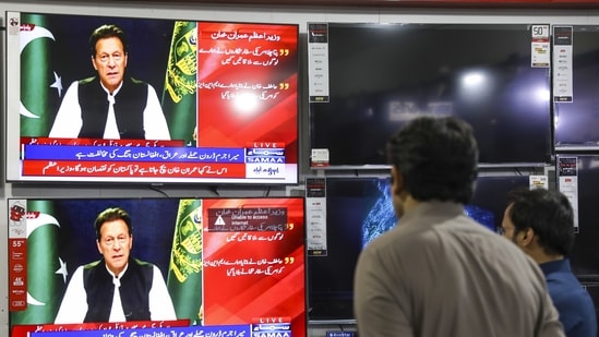 Televisions broadcast live footage of Imran Khan, Pakistan's prime minister, in Rawalpindi, Pakistan, on Friday, April 8, 2022.(Bloomberg)