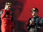 Ferrari driver Charles Leclerc of Monaco celebrates after winning the Australian Formula One Grand Prix as third placed Mercedes driver George Russell, right, of Britain watches in Melbourne, Australia.(AP)