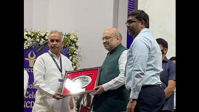Union home minister Amit Shah presenting the active participation award to Haryana Dairy Development Cooperative Federation chairperson Randhir Singh and managing director A Sreenivas in Gandhinagar. (HT Photo)