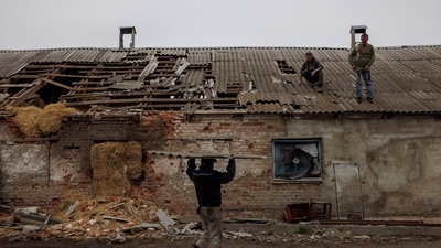 Workers repair the roof of a farm building that was damaged by a mortar, in the village of Malaya Rohan, as Russia's attack on Ukraine continues, in the Kharkiv region. (Reuters)