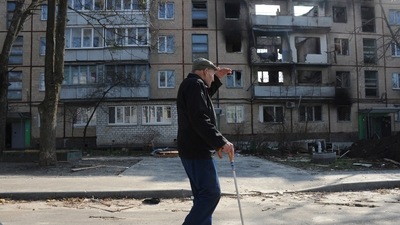 A man walks past an apartment building damaged by shelling in Kharkiv, Ukraine. (AP Photo)