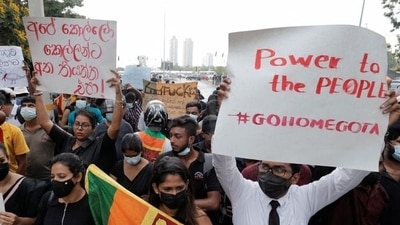 People hold placards as they demand Sri Lanka's President Gotabaya Rajapaksa to resign after his government lost its majority in the parliament, amid the country's economic crisis, during a protest near to a road leading to the parliament building in Colombo, Sri Lanka. REUTERS/Dinuka Liyanawatte