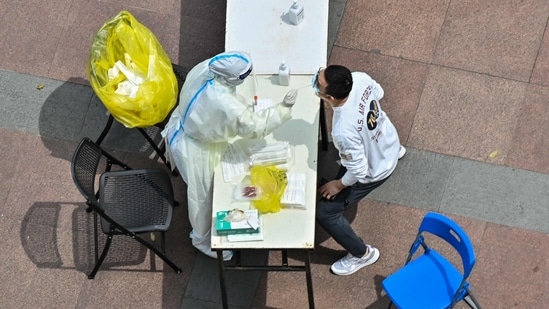 A health worker wearing personal protective equipment (PPE) conducts a swab test for the Covid-19 coronavirus in a compound during a Covid-19 lockdown in the Jing'an district in Shanghai on April 10, 2022.&nbsp;(AFP)