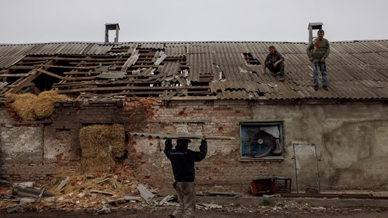Workers repair the roof of a farm building that was damaged by a mortar, in the village of Malaya Rohan, as Russia's attack on Ukraine continues, in the Kharkiv region.(Reuters)