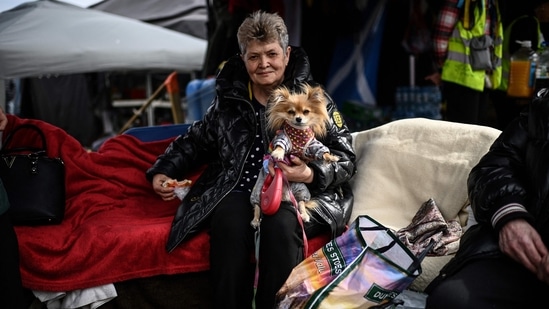 An Ukrainian refugee (C) holds her pet dog as she sits at an NGO tent at the Ukrainian-Polish border on her way out of Ukraine, in Medyka, eastern Poland on Friday. Europe has not seen such a flood of refugees since World War II.(Photo by Christophe ARCHAMBAULT / AFP)