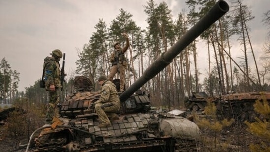 A Ukrainian serviceman takes a selfie standing on a destroyed Russian tank after Ukrainian forces overran a Russian position outside Kyiv.(AP)